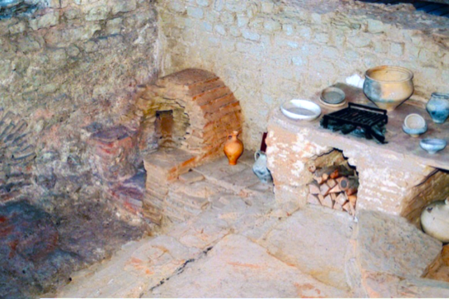 Basic Roman kitchen with a simple wood fired oven in the corner.