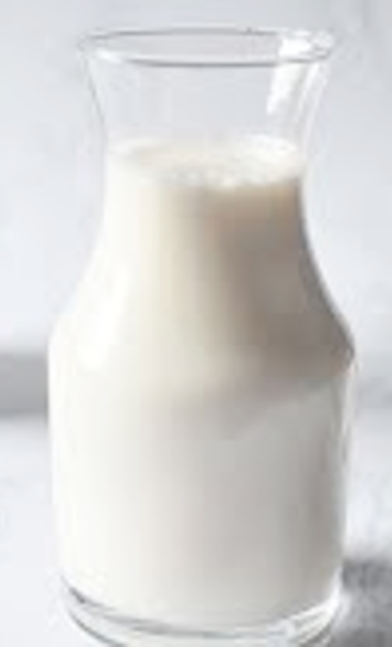 Glass of almond milk and unblanched almonds
