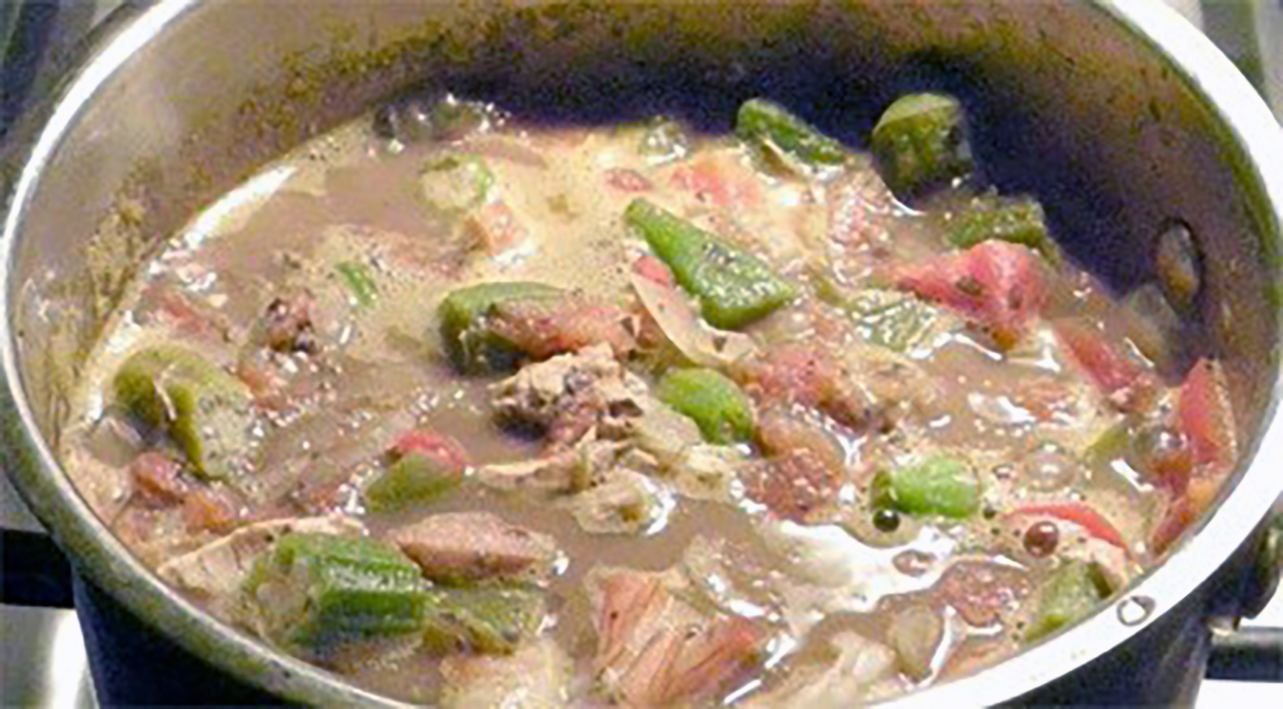 Classic cajun gumbo of chicken and seafood simmering in a pot