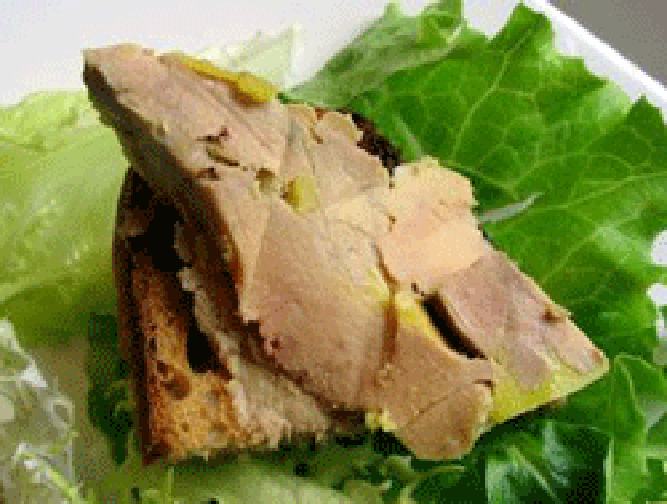 Foie gras on toast shown on a bed of lettuce leaves