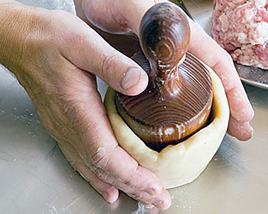 Hot water crust for pork pies shaped around a wooden form