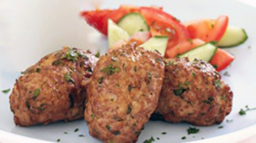 Three meat rissoles with tomato and cucumber salad