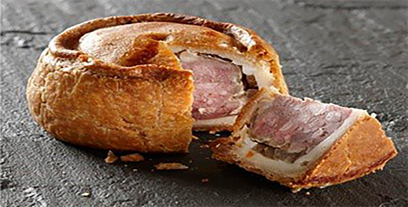 Classic rich raised pork pie with a wedge excised