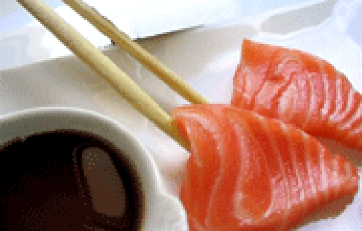 Raw salmon sashimi served with soy sauce for dipping