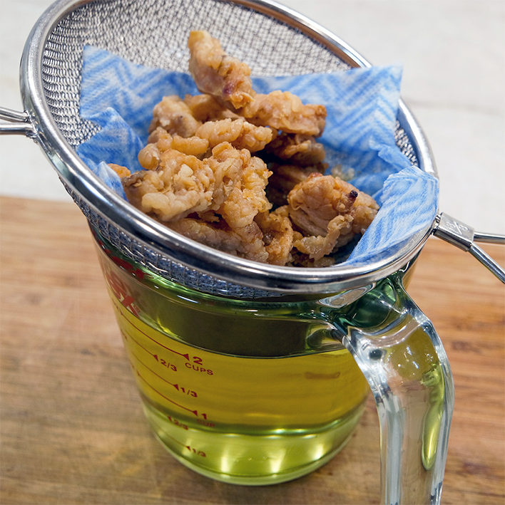 Straining rendered fat into a jug