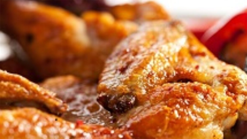 spicy chicken winges served on a bed of rice with onion and bell peppers in which they were cooked