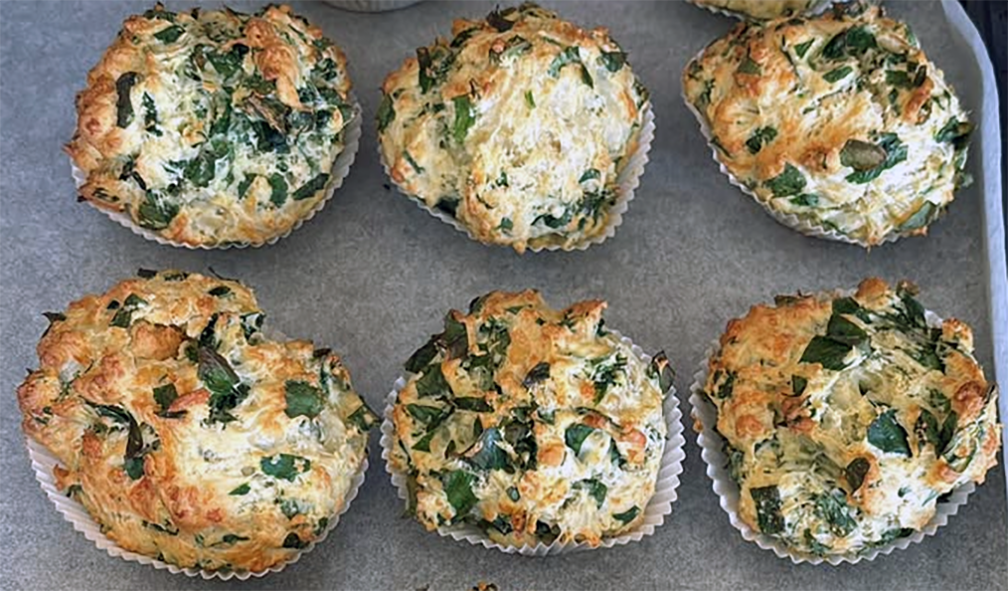 six alexanders seeds and wild greens cheese scones in baking cases on a sheet of greaseproof paper