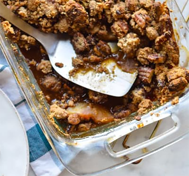 apple gingerbread cobbler in a baking dish with a portion removed
