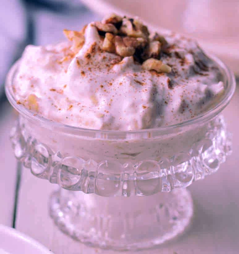 apple and rose hip mousse served in a glass dish garnished with nuts and ground cinnamon