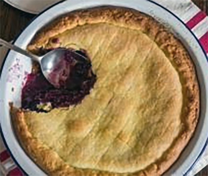 Apple and tamarillo pie with a piece spooned out to reveal the filling