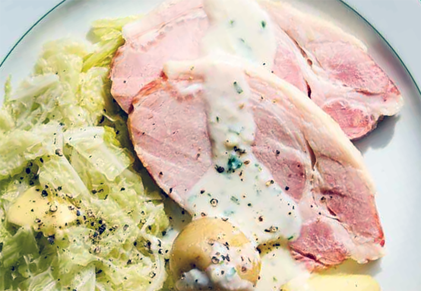 sliced bacon joint served with cabbage and parsley joint on a plate