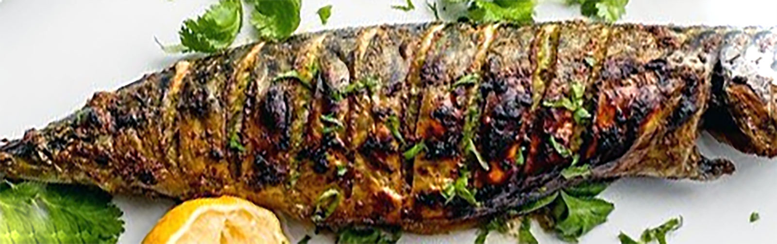 baked mackerel on a plate garnished with parsley leaves