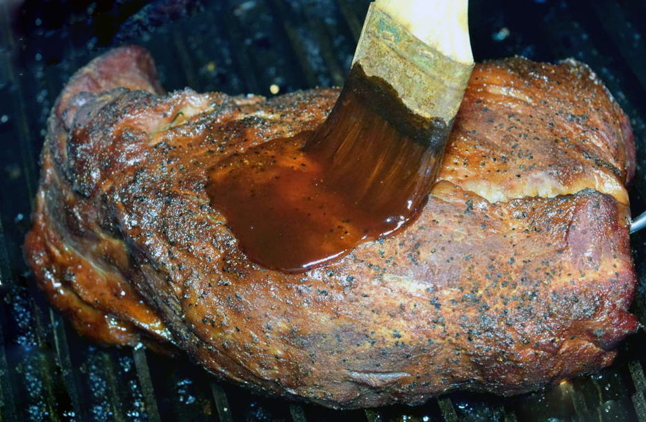 tri-tip steak on a barbecue brushed with burbon glaze