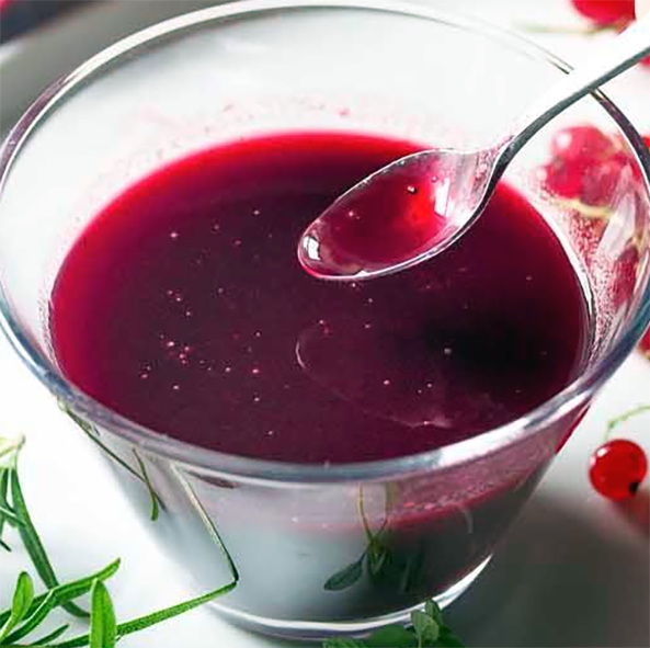 port wine and redcurrant jelly sauce in a glass with a spoon