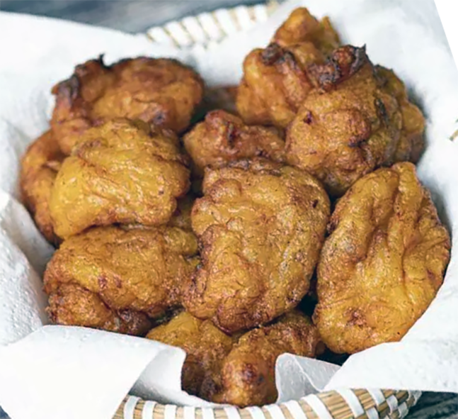 Banana fritters served in a basket lined with kitchen paper