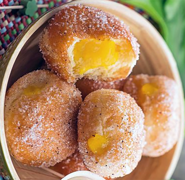 beignets de la mangue, Senegalese mango fritters in a bowl with one split to show the centre