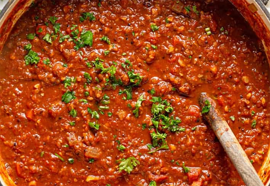 bolognese pizza sauce cooking in a large pan</a>