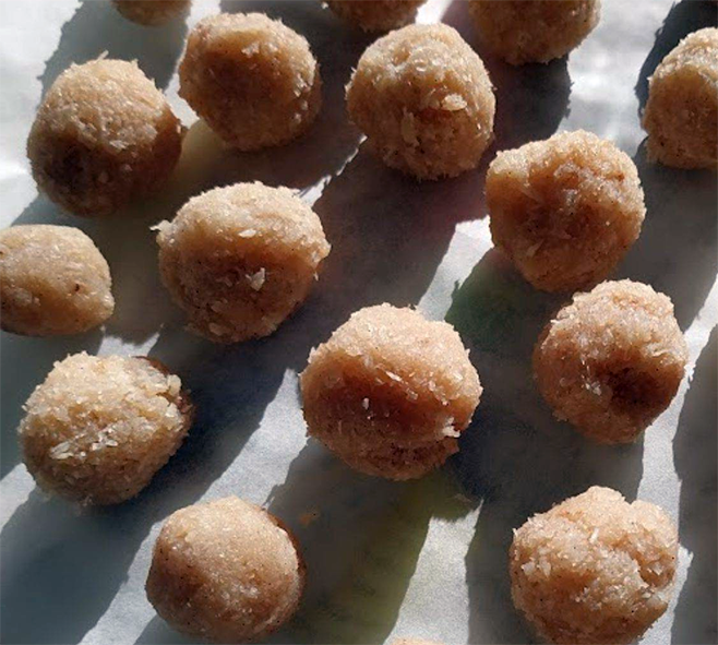 Mauritian coconut candy balls drying on a sheet of greaseproof paper
