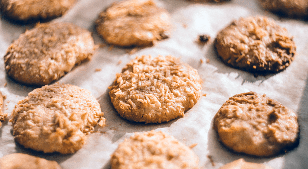 coconut oatmeal drop biscuits on a parchment lined baking tray