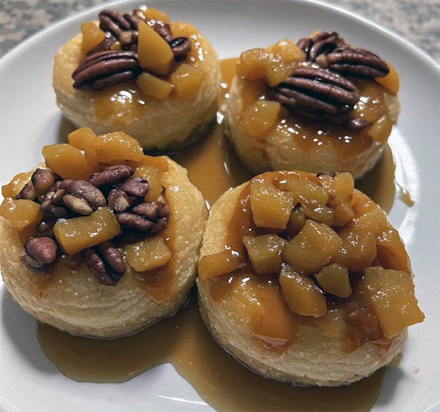 Individual almond sponges topped with chopped apricots and pecans served with toffee sauce