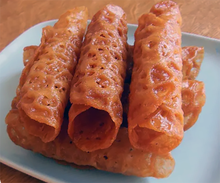 Tubular brandy snap biscuits piled on a plate