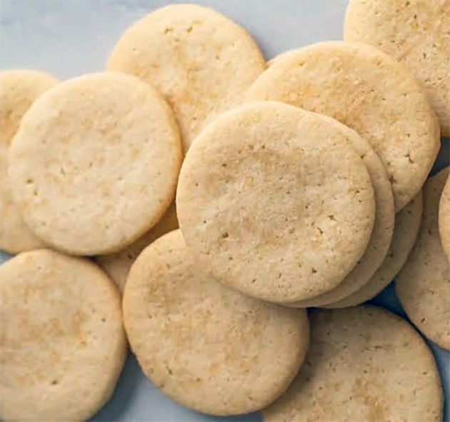 butter cookies piled on a sheet of waxed paper