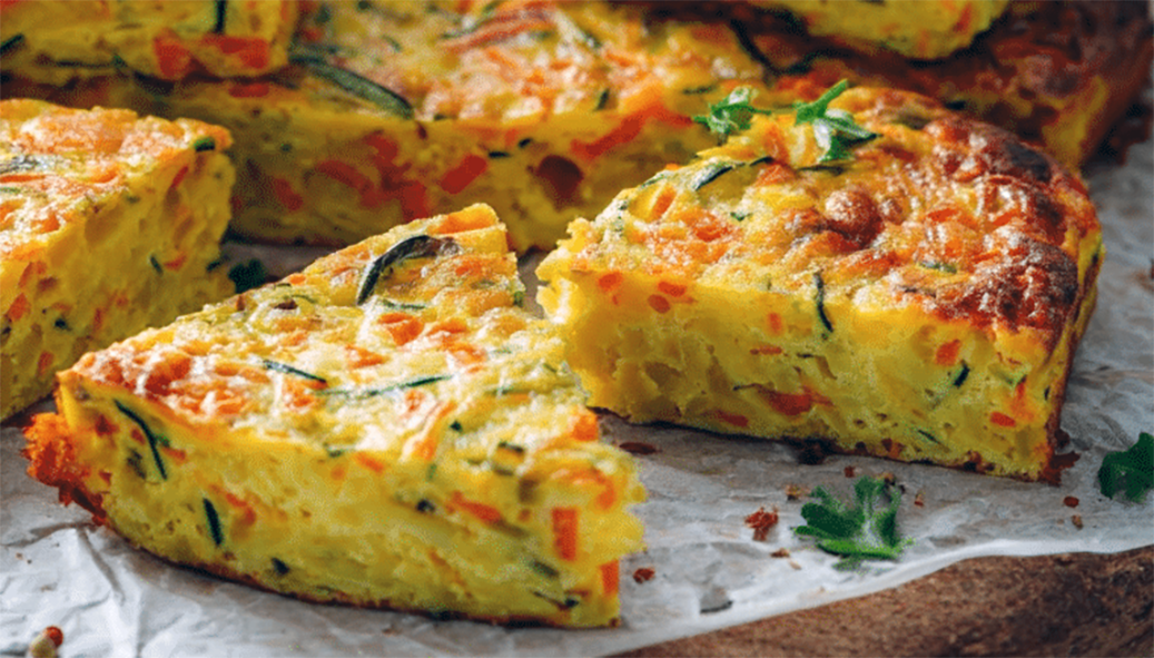 Wedges of carrot, potato and onion cake on a greaseproof lined chopping board