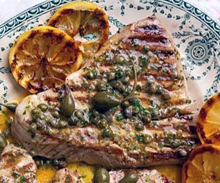 barbecued tuna steaks and lemon slices with a dill and caper dressing