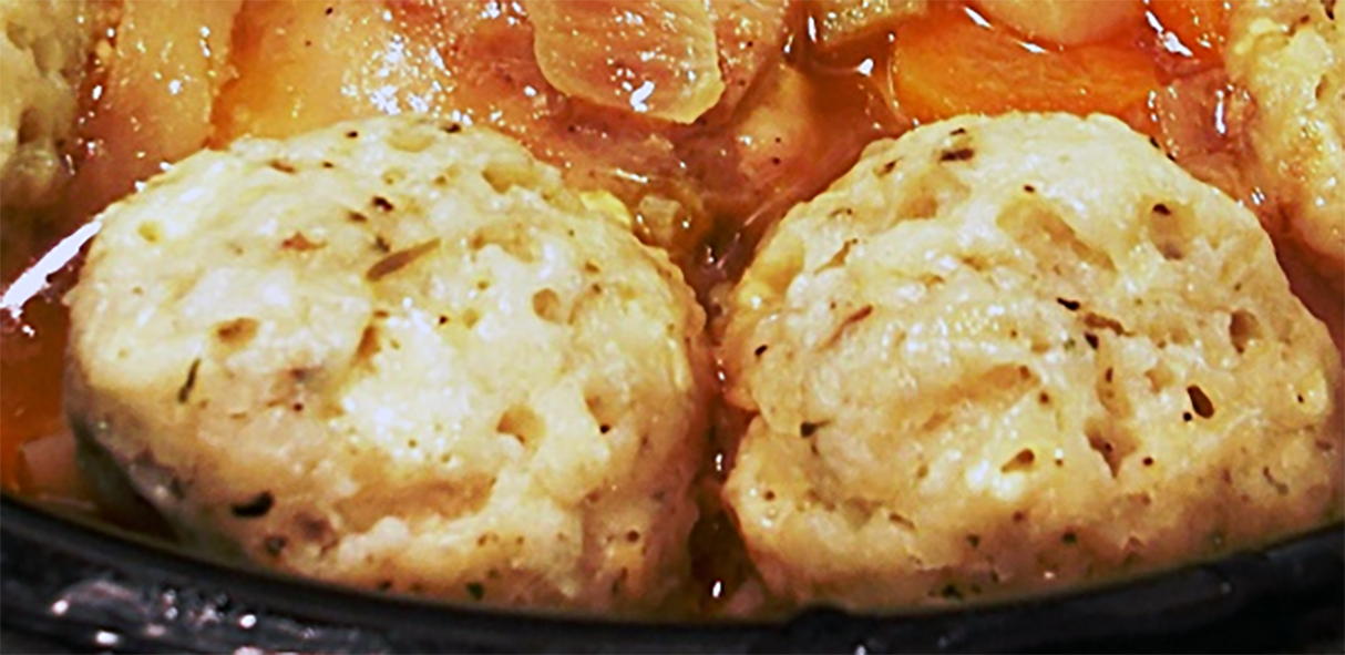 two cheese dumplings on top of a chicken stew