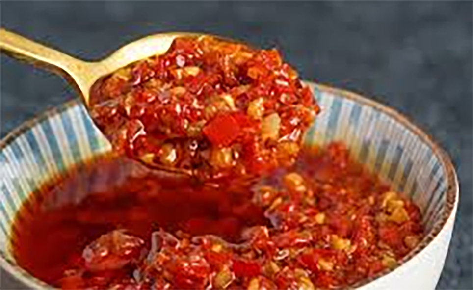 Chinese chilli sauce dropping from a spoon into a bowl</a>