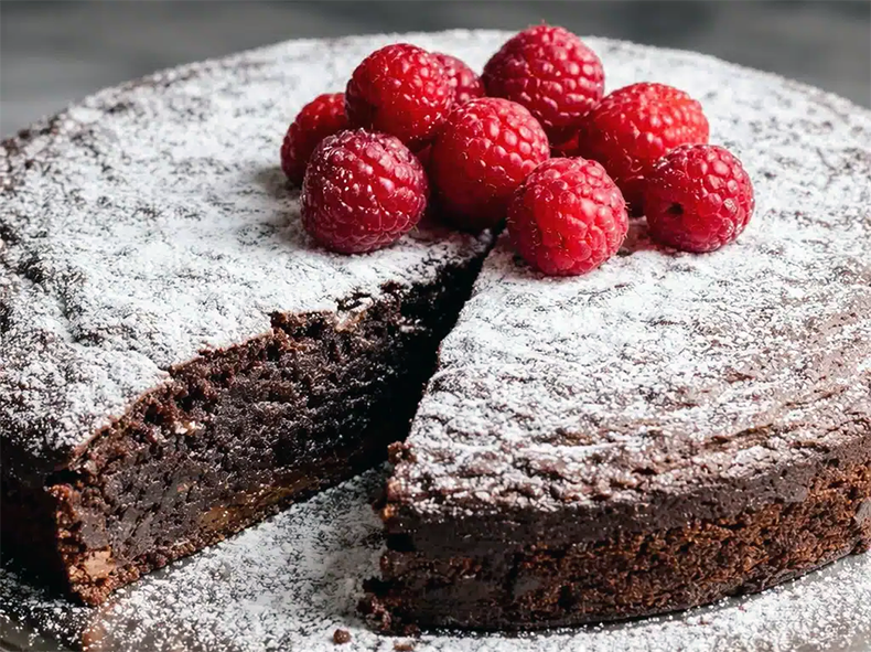 chocolate and bird cherry flour cake garnished with powdered sugar and raspberries