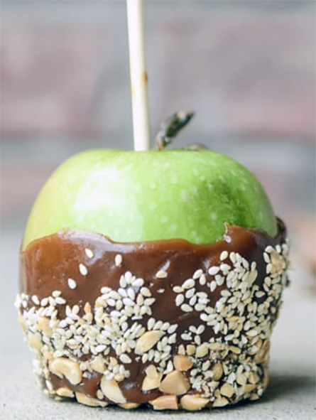 apple part coated in peanut butter and chocolate with a nut topping