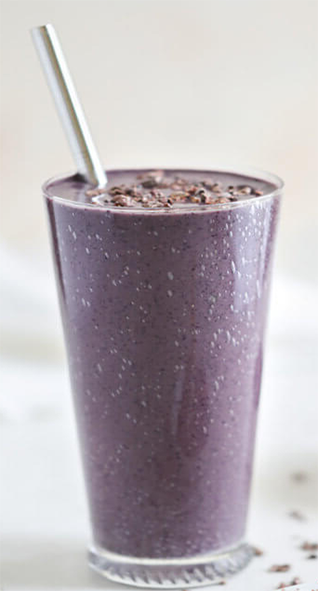cocoa berry smoothie garnished with grated chocolate in a tall glass
