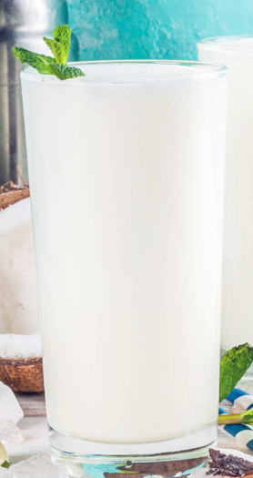 coconut ginger smoothie with a sprig of mint in a glass