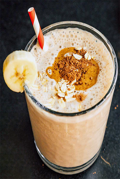 coffee smoothie in a tall glass garnished with a slice of banana