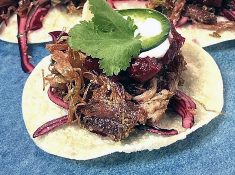 confit of duck tostada on a blue plate