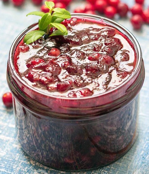 cowberry jam in a jar with a sprig of mint