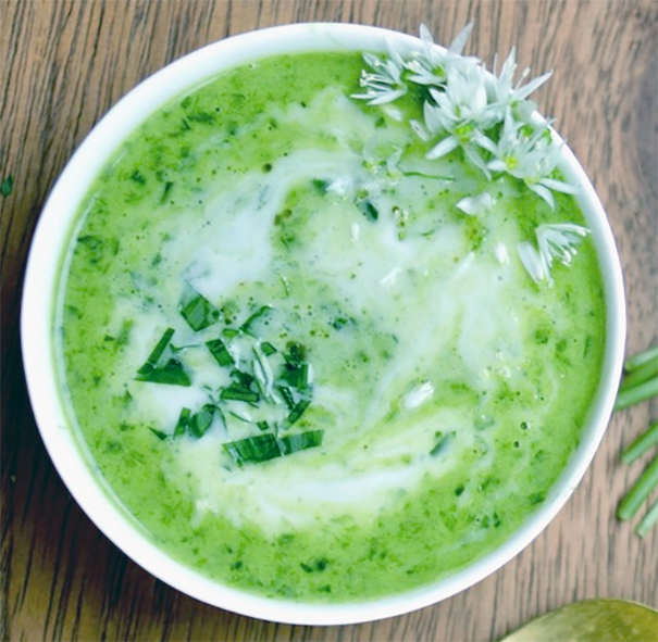 cream of nettle and wild garlic soup in a bowl garnished with shredded wild garlic leaves and wild garlic flowers