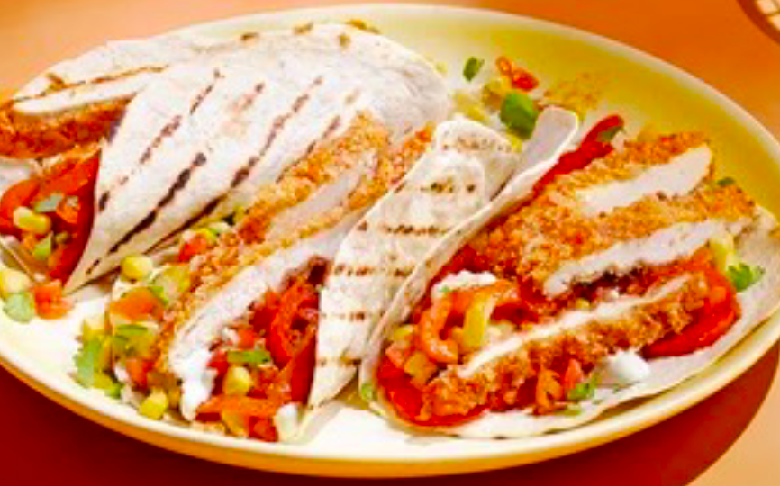 crispy chipotle chicken fajitas folded up and arranged on a serving plate</a>
