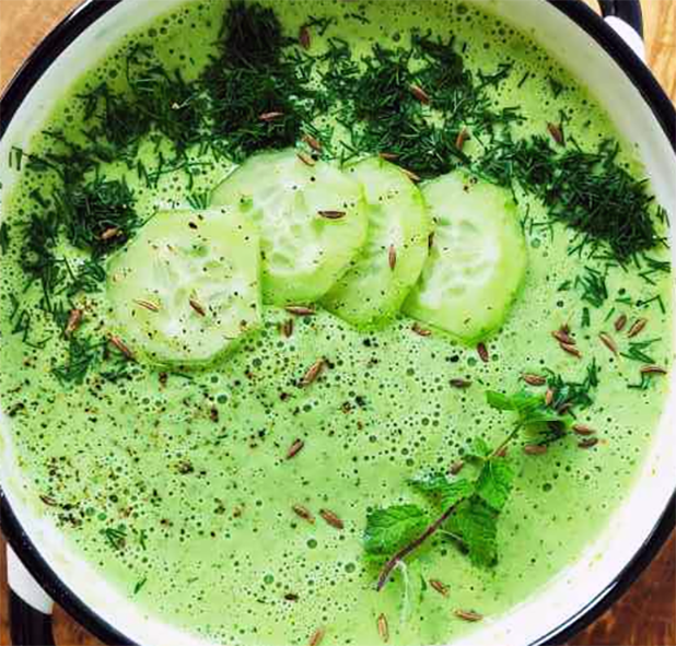 cucumber and mint soup in an enamelled dish served garnished with chopped mint and cucumber slices