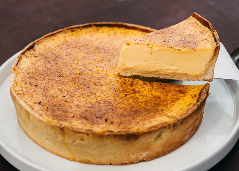 rustic elizabethan custard tart with one wedge lifted with a cake slice