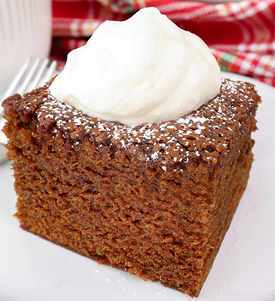 square of gingerbread cake mix cake dusted with icing sugar and served with a dollop of yoghurt
