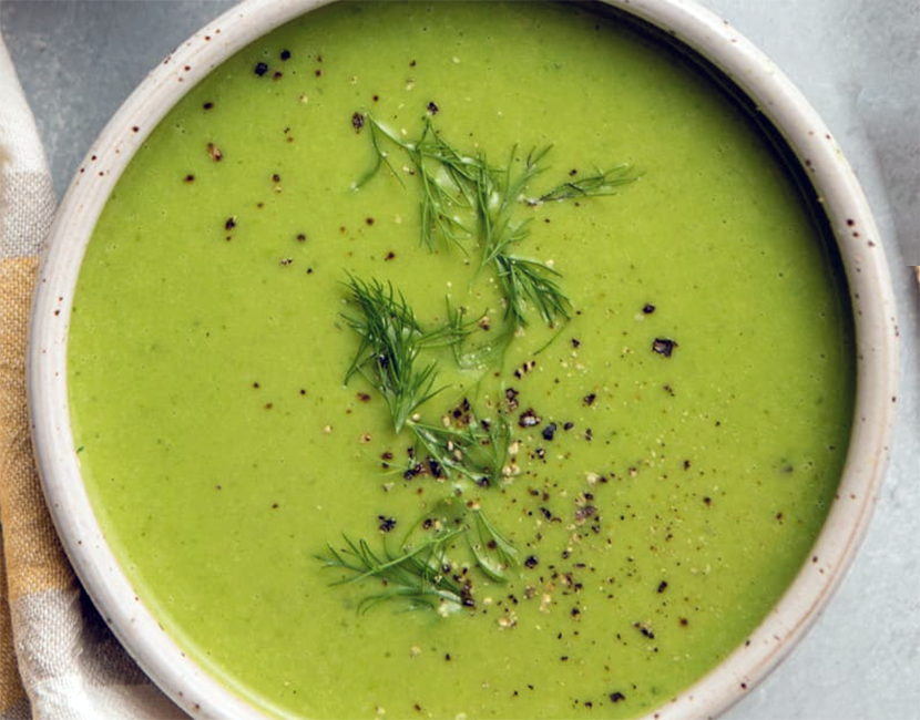 pureed pea and three-cornered leek soup served in a bowl and garnished with sprigs of dill