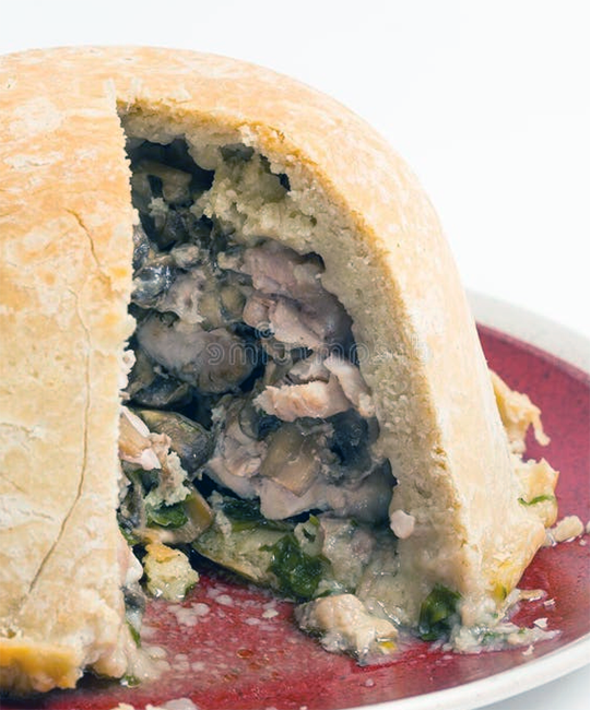 guinea fowl and mushroom pudding with a wedge removed to reveal the filling