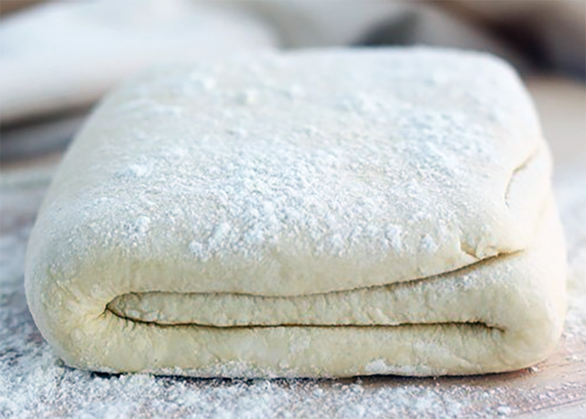 hojaldre puff pastry folded on a floured board