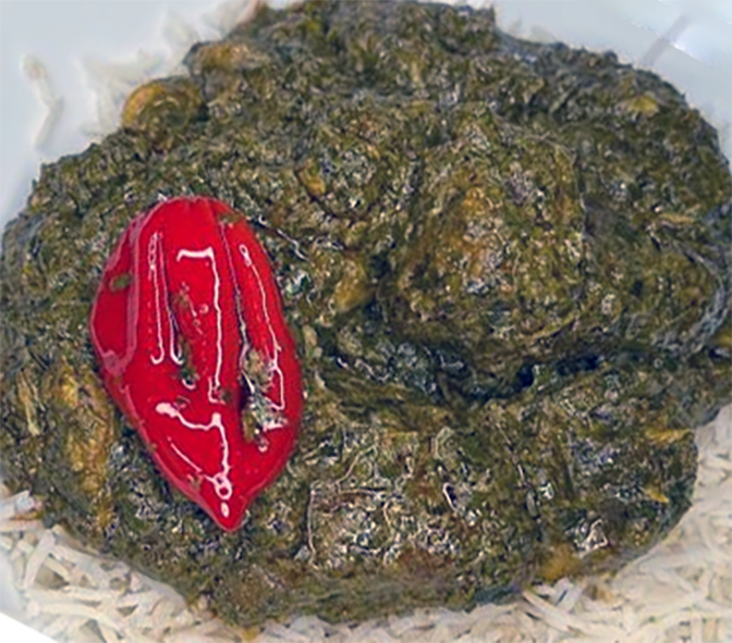 beef in peanut and hibiscus leaf sauce served on a bed of rice with a red chilli