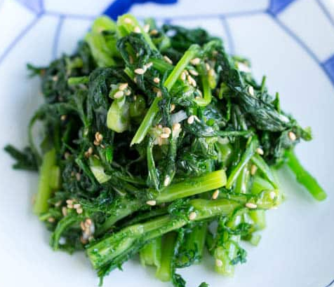 chopped chrysanthemum or oxeye daisy greens that are blanched, blended with seasonings, garnished with sesame seeds and served