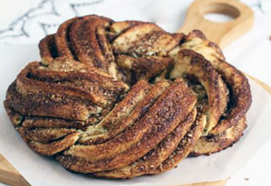Estonian cinnamon braid bread on a wooden chopping board