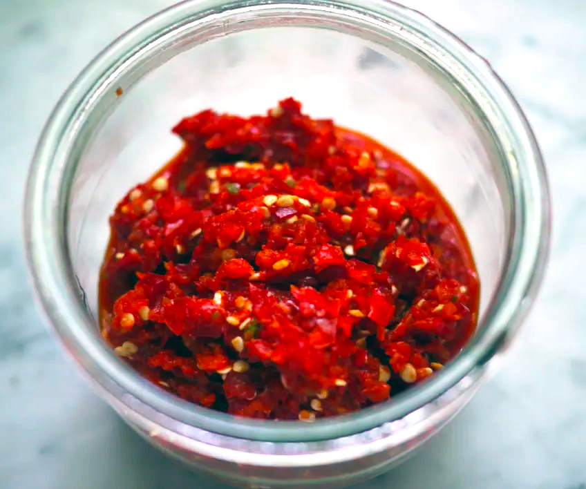 Lajiaojiang, Sichuan Hot Pickled Chilli Sauce shown in an overhead view of a glass jar