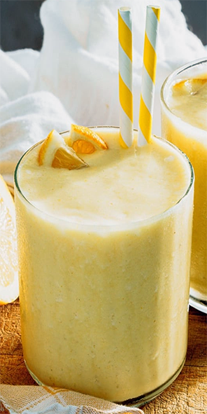 Lemon sweet tart smoothie served in a glass and garnished with lemon slices and two straws
